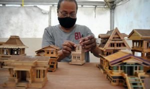 Perajin mengerjakan pembuatan kerajinan miniatur rumah dari bahan stik es krim saat Pesta Rakyat di Kota Bogor, Jawa Barat, Senin (8/2/2021).